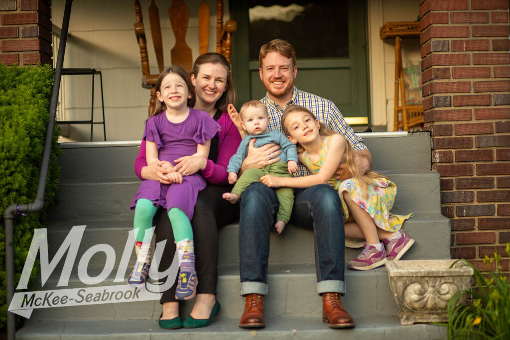 Molly, her husband, and their three children sitting on the stoop of their Hyattsville home.