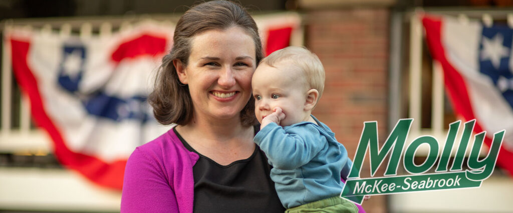 Molly holding her youngest child in front of her home in Hyattsville