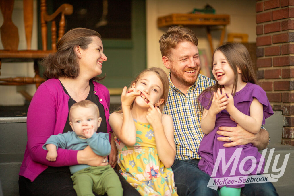 Molly, her husband, and their three children laughing and making playful faces on the stoop of their Hyattsville home.